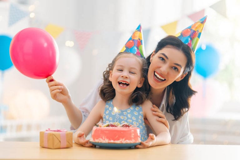 Tante und Tochter feiern Geburtstag mit Kuchen zu Hause