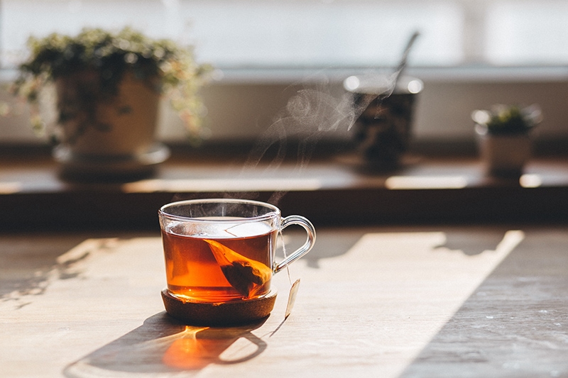 Glasbecher mit Tee auf dem Tisch
