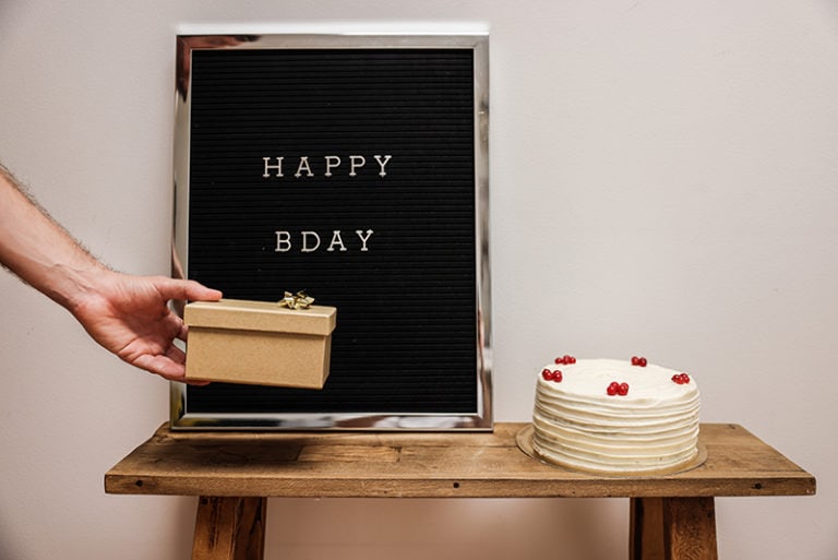 ein Mann hinterlässt eine Geschenkbox neben dem Kuchen