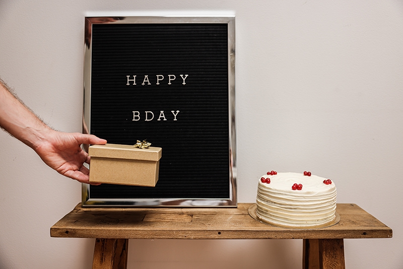 ein Mann hinterlässt eine Geschenkbox neben dem Kuchen