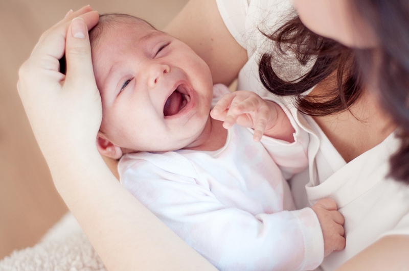 Mutter hält ihr weinendes Baby und tröstet sie