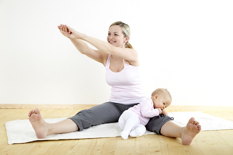 Mutter macht Sport mit ihrem Baby auf dem Boden