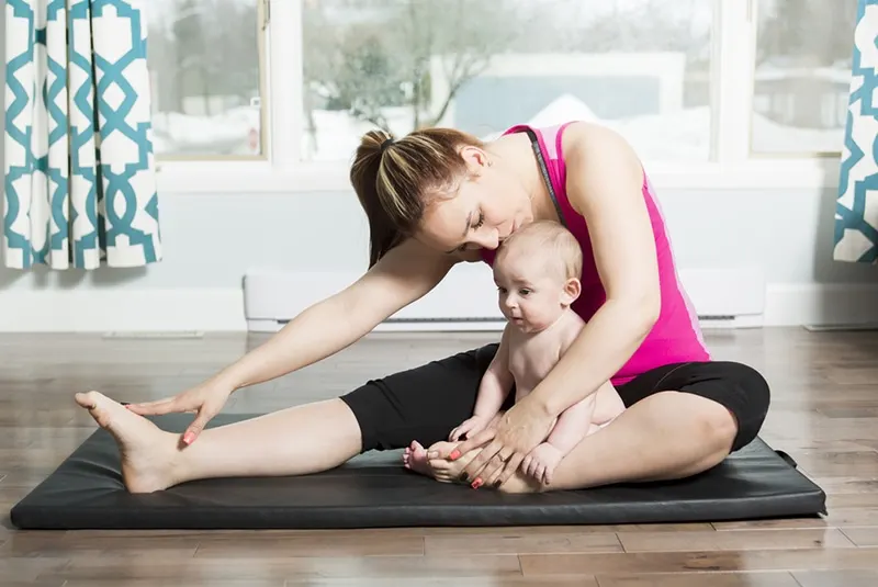 Mutter mit Kind macht Fitnessübungen zu Hause
