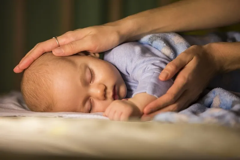 neugeborenes Baby schläft im Kinderbettchen ein