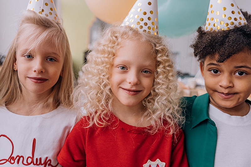 Drei kleine Kinder auf der Geburtstagsfeier