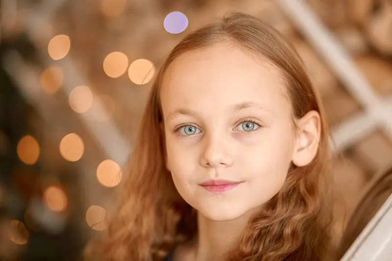 kleines Mädchen mit blauen Augen und langen braunen Haaren