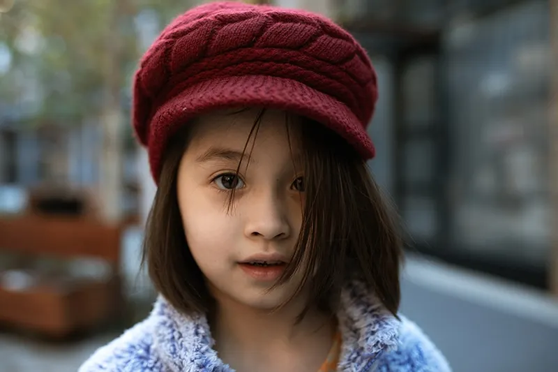 kleines Mädchen mit kurzen Haaren mit roter Mütze