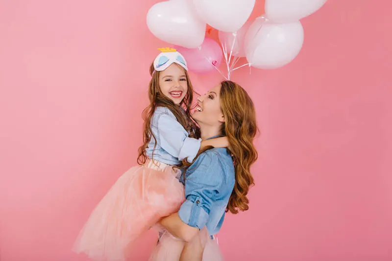 kleines Mädchen posiert mit ihrer Tante auf der Geburtstagsparty