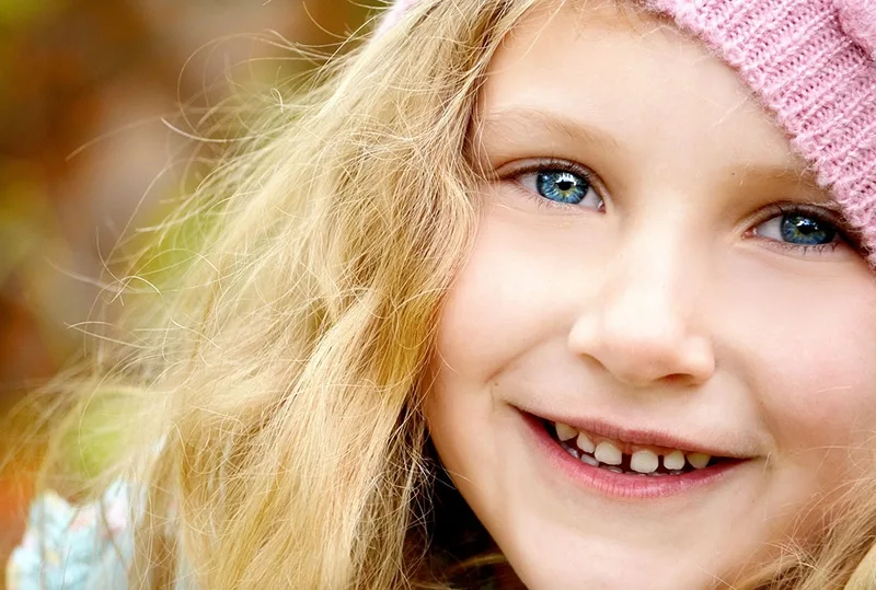 lächelndes kleines Mädchen mit blauen Augen und blonden Haaren