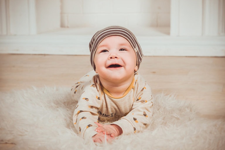 Baby liegt auf Teppich