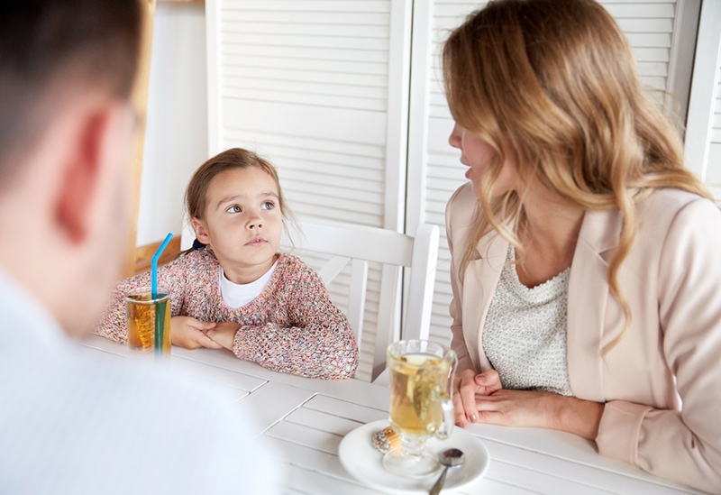 Eltern sprechen mit ihrer Tochter beim gemeinsamen Teetrinken