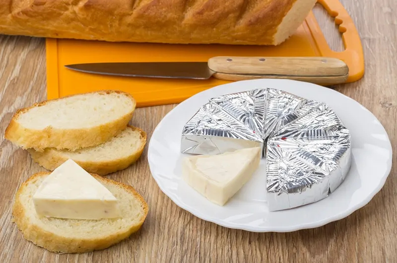 Geschmolzener Käse in Folie auf Teller