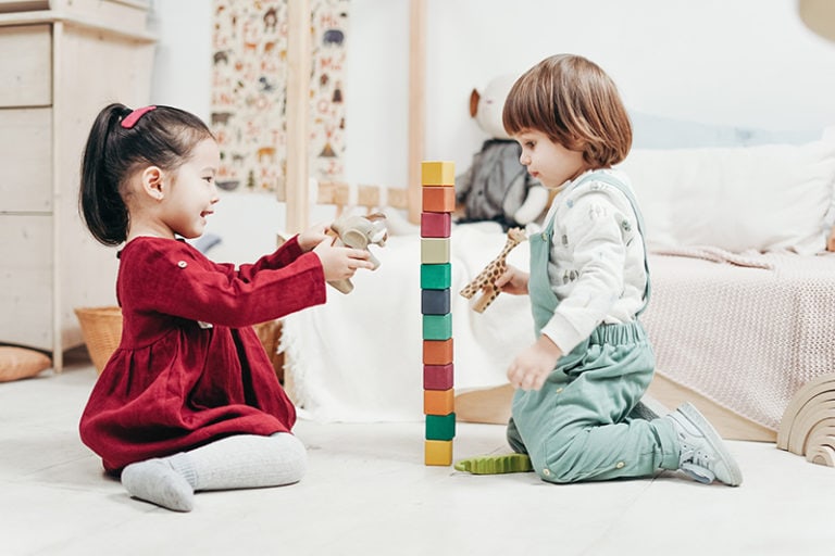 Kinder spielen mit Holzklötzen