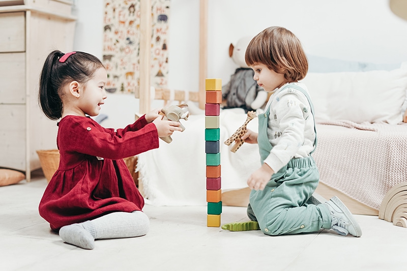Kinder spielen mit Holzklötzen