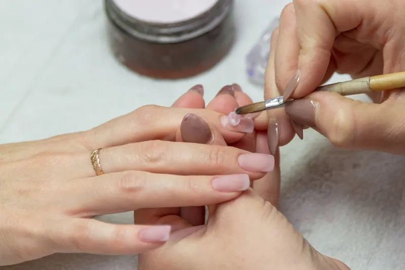 Maniküre-Spezialist macht Acrylnägel im Schönheitssalon