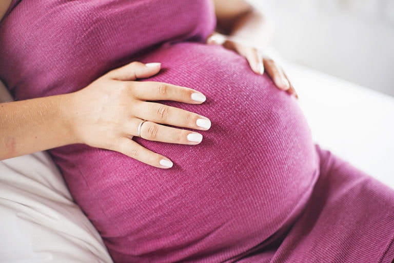 schwangere frau, die ihren bauch berührt