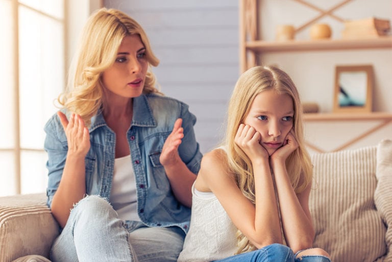 mutter schimpft tochter, die zu hause auf der couch sitzt