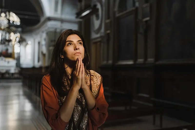 Frau, die in der Kirche betet