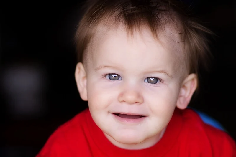 ein kleiner Junge im roten Hemd lächelt