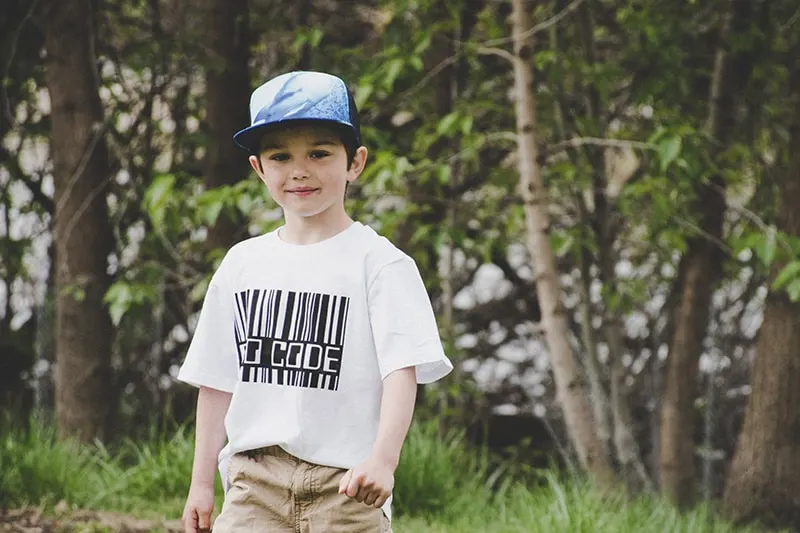 kleiner Junge mit Mütze im Park stehen