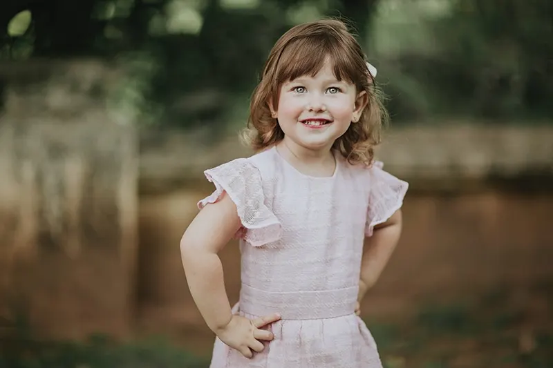 süßes kleines Mädchen in einem Kleid, das draußen steht
