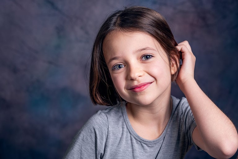 süßes Mädchen, das Haare mit der Hand berührt