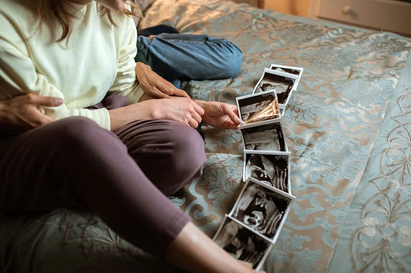 Zukünftige Eltern sehen sich zu Hause Ultraschallbilder an