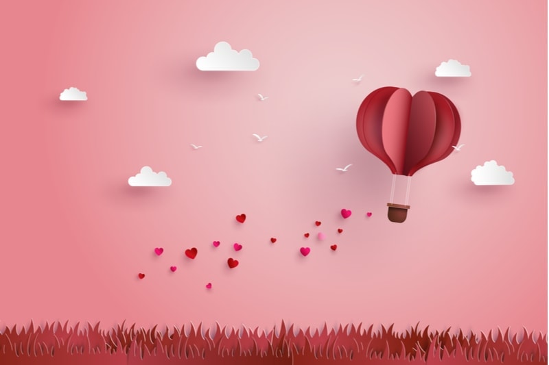fliegender rosa Ballon mit Herzen