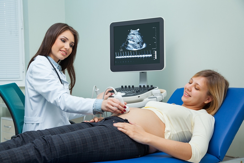 junge schwangere frau auf der ultraschalluntersuchung der schwangerschaft