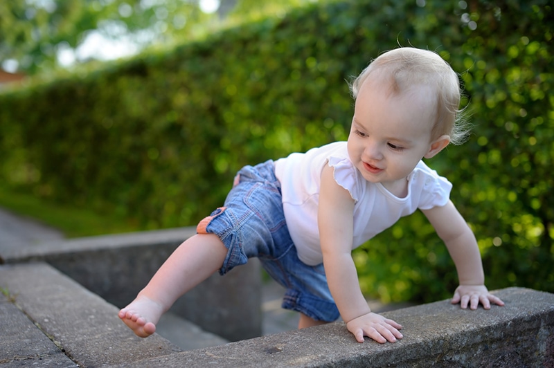 kleines Mädchen klettert auf Treppen im Hof