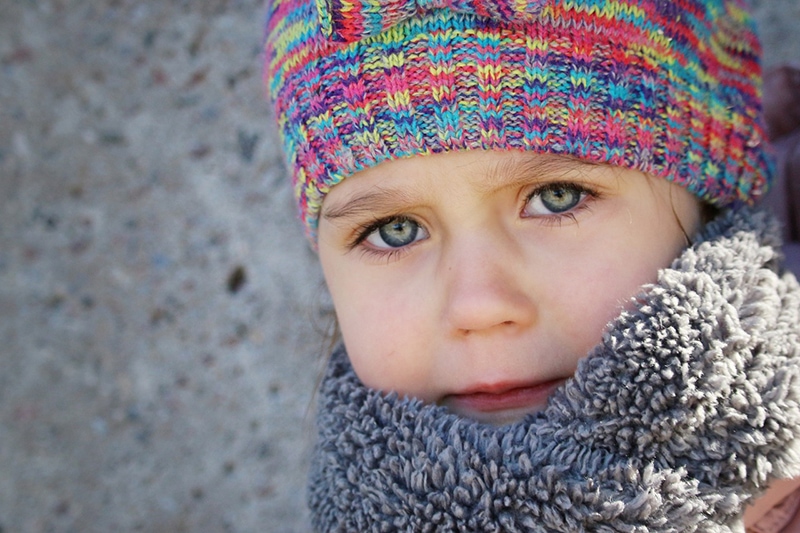kleines Mädchen mit Wollmütze und Schal