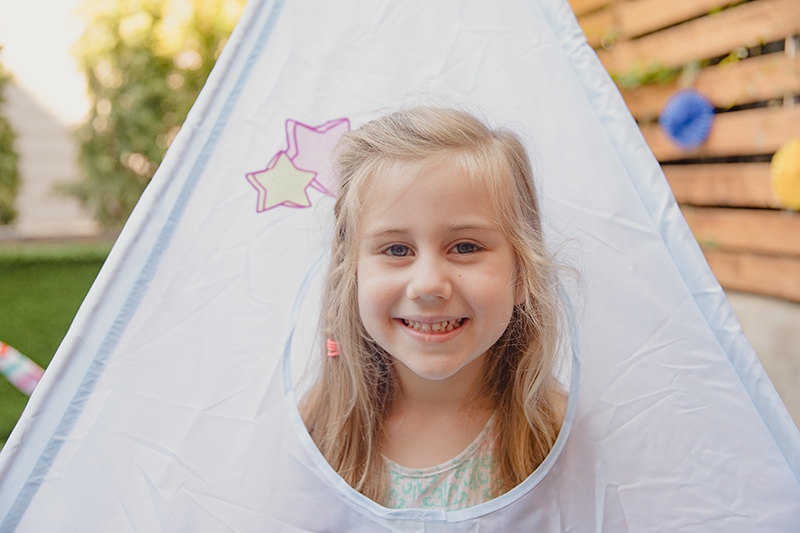 kleines lächelndes Mädchen in einem Zelt