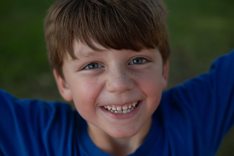 lächelnder Junge im blauen Hemd