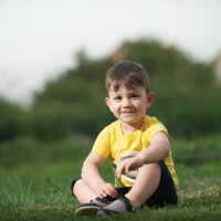 kleiner Junge sitzt im Gras