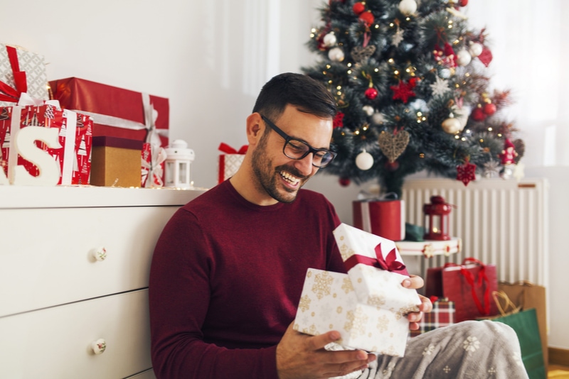 glückliche Männer öffnen Geschenk