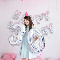 Frau feiert 30. Geburtstag mit Luftballons