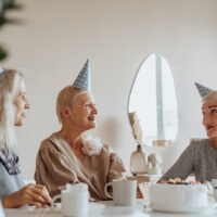 ältere Frau, die mit Freunden Geburtstag feiert