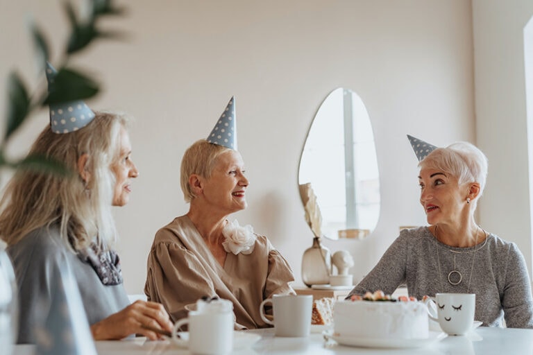 ältere Frau, die mit Freunden Geburtstag feiert