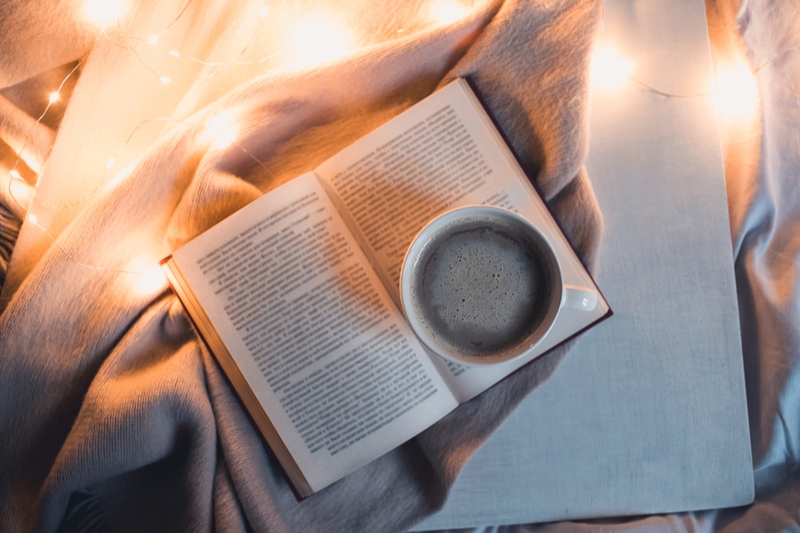 Buch und Kaffee auf dem Bett