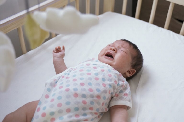 müdes Baby weint in der Krippe