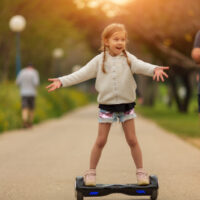 kleines Mädchen auf Hoverboard im Park