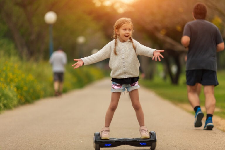 kleines Mädchen auf Hoverboard im Park
