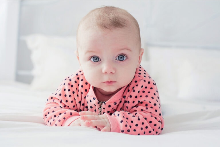 Baby auf dem Bett, das in die Kamera schaut