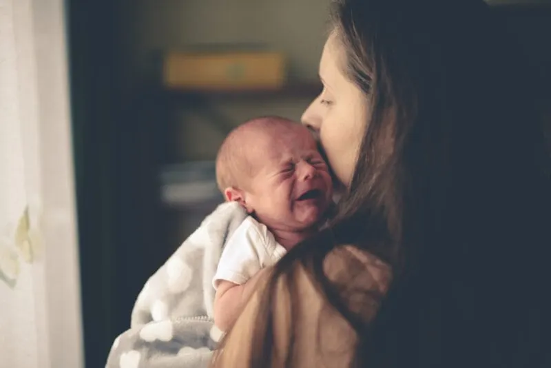 Mutter hält ihr weinendes Neugeborenes