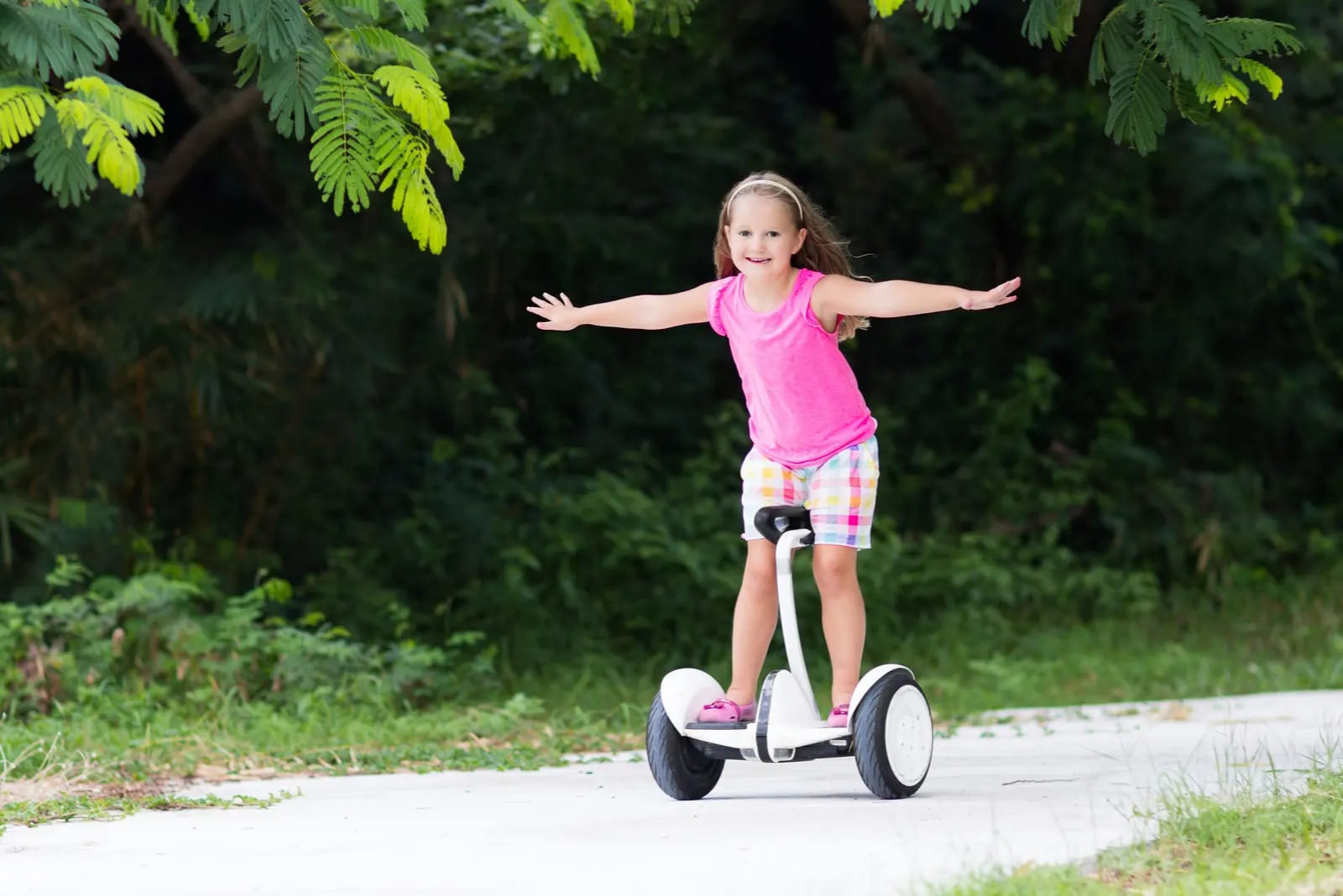 glückliches kleines Mädchen mit Hoverboard