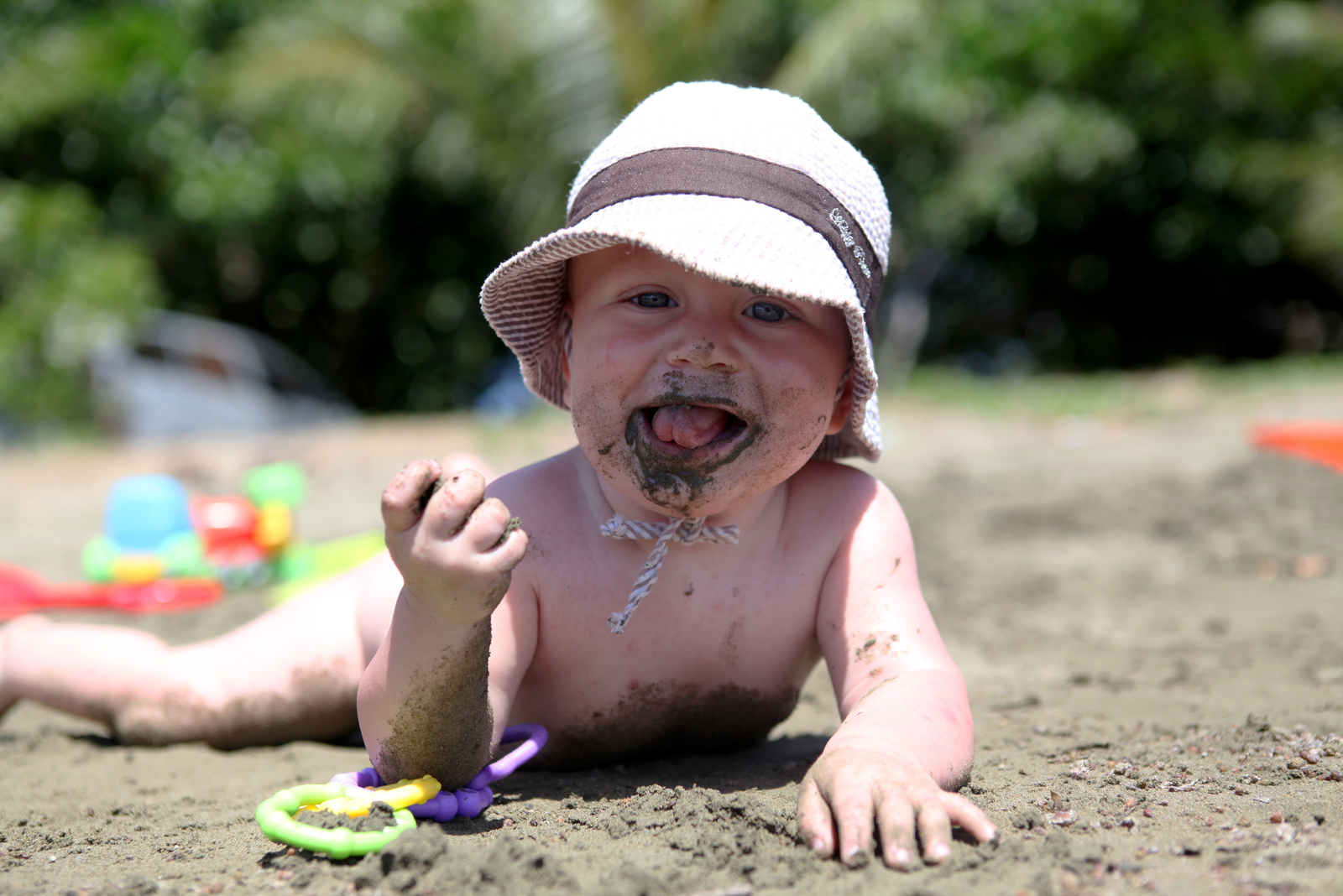 Baby isst Sand am Strand