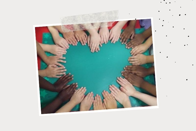 Gruppenfoto von Kinderhänden, die ein Herz bilden. 
