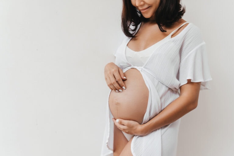 schwangere frau berührt ihren bauch