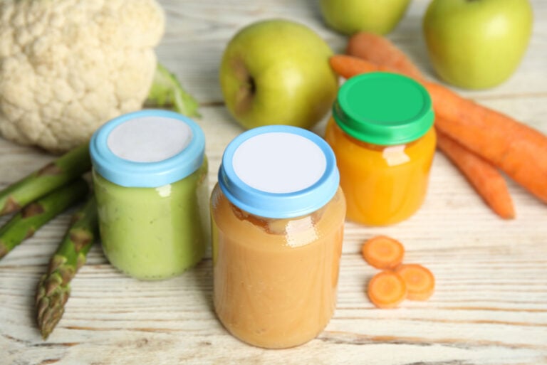 Gläschen mit Babynahrung, Gemüse und Obst auf dem Tisch