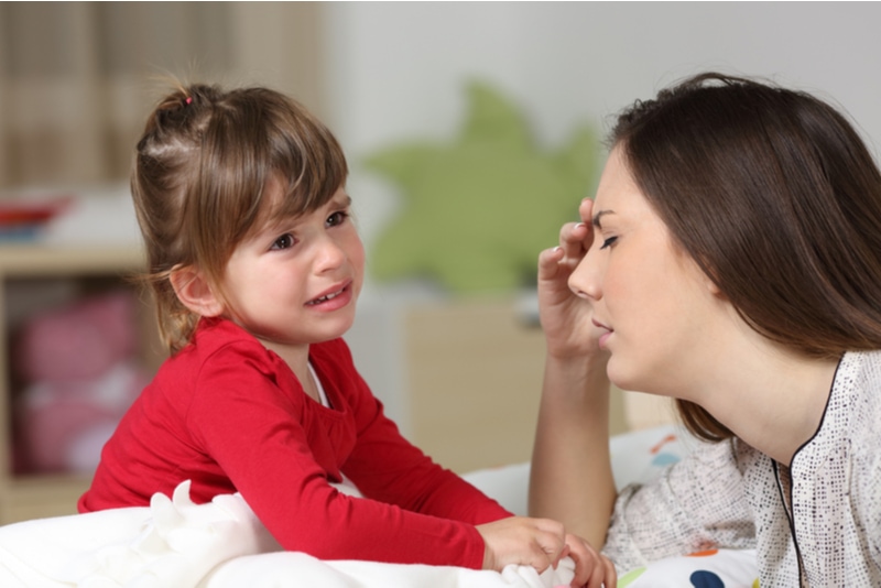 Eine Frau hört ihre zweijährige Tochter weinen